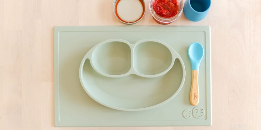 Placemat, spoon, cup, and food used in infant feeding